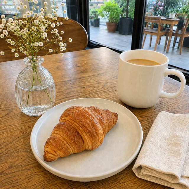 Original café photo of a croissant and coffee